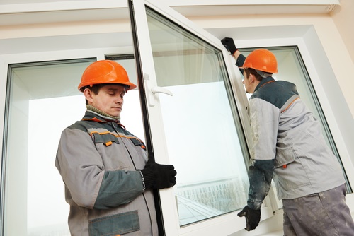 Two male industrial builders workers at window installation