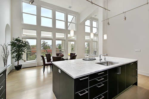 Modern kitchen in condominium with two story windows