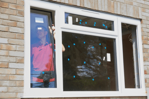 Technician installing window in building